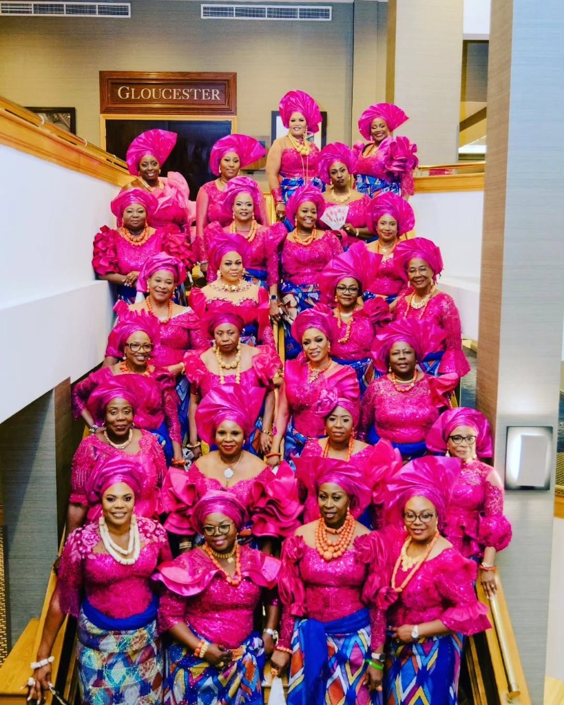 OFUSA members in traditional pink gele and patterned wrappers posed together on a staircase